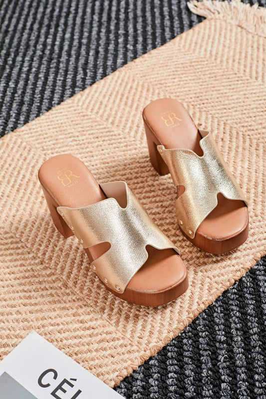 Paire de mules tendance dorées avec bride découpée et rivets dorés.