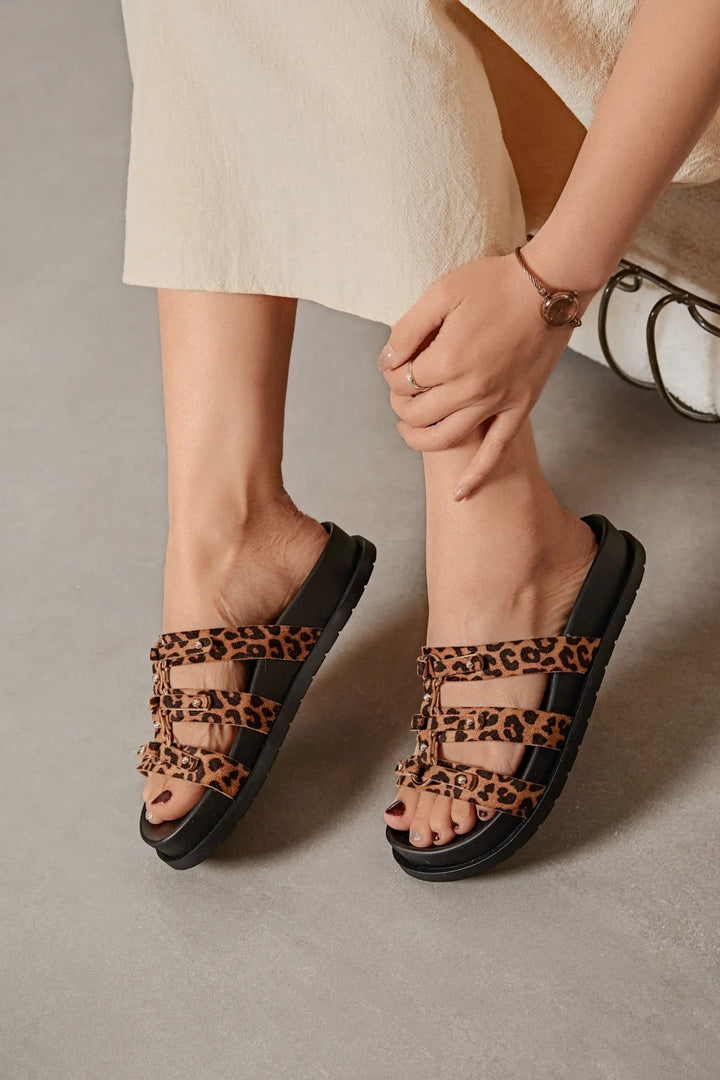 Sandales léopard femme chic posées sur canapé blanc