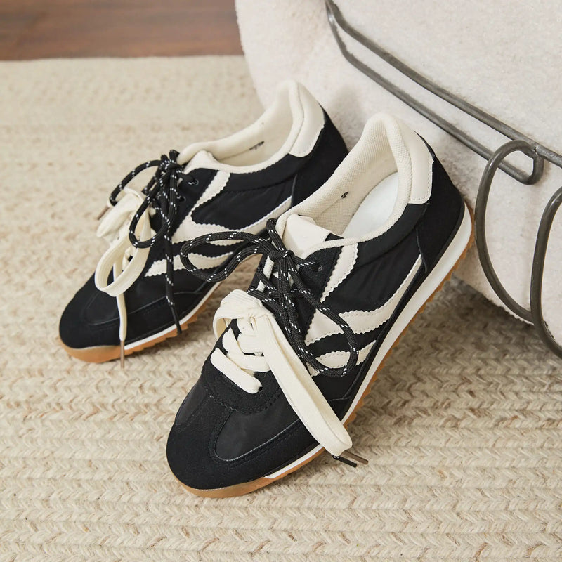 Vue de profil des baskets basses noires à bandes blanches Milie
