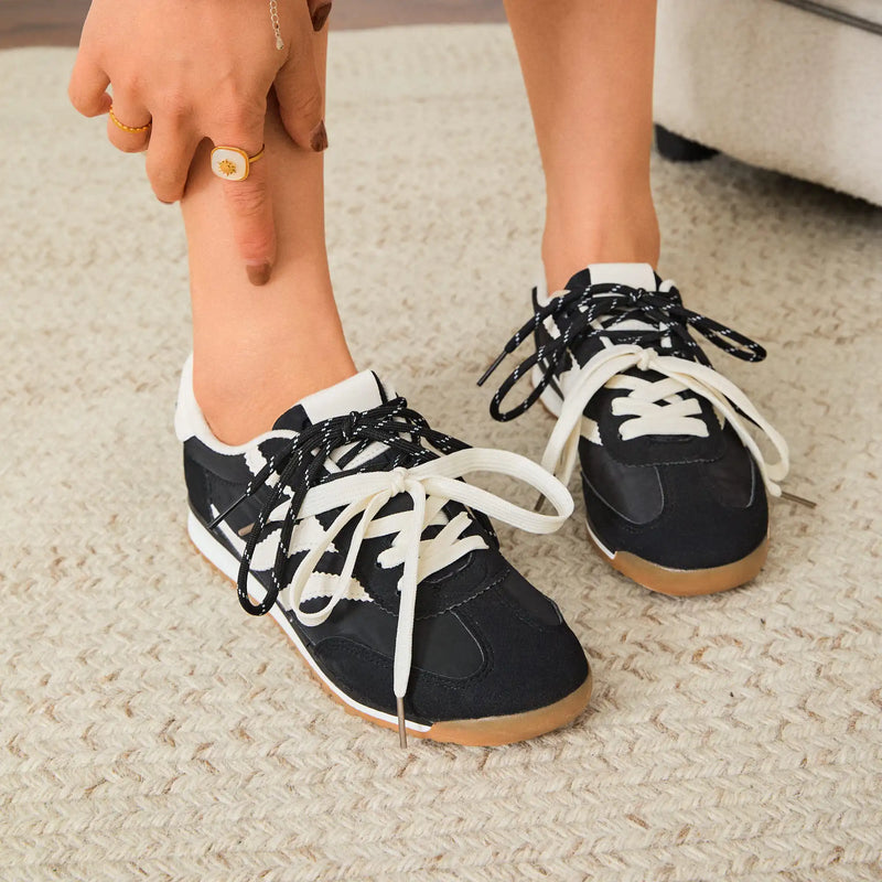 Détail du laçage contrastant sur la tige noire des baskets Milie